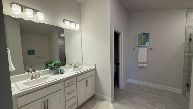 full bath featuring a sink, baseboards, and double vanity