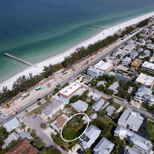 drone / aerial view featuring a water view and a beach view