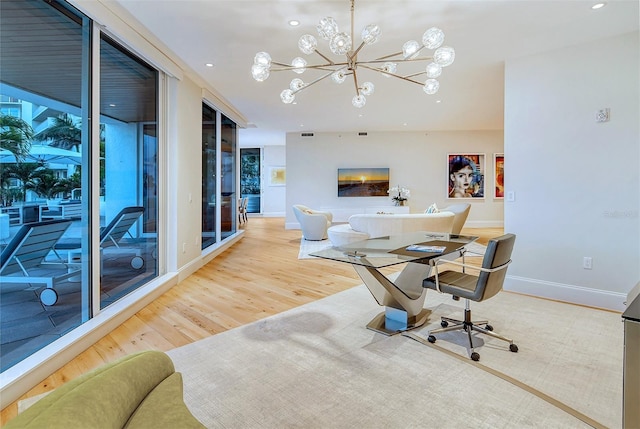 office with light wood-type flooring and an inviting chandelier