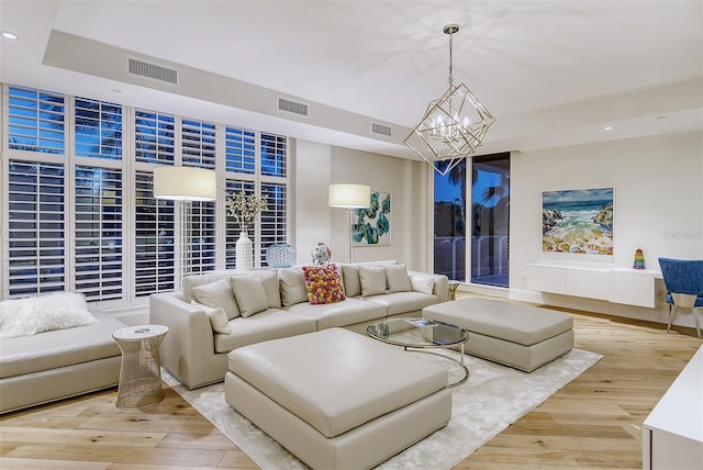 living room featuring light hardwood / wood-style flooring and an inviting chandelier