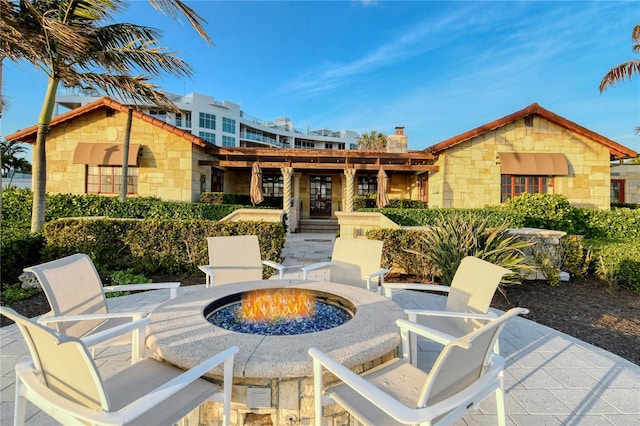 back of property featuring a patio and a fire pit