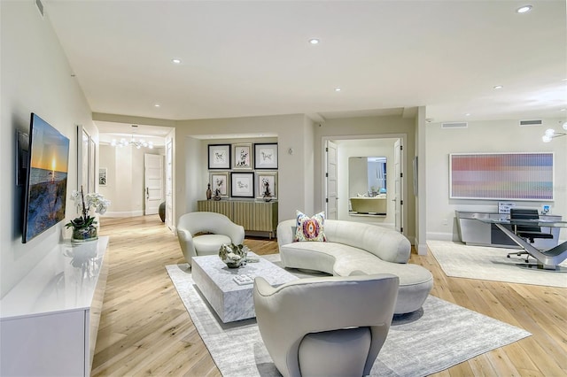 living room featuring a chandelier and light hardwood / wood-style flooring