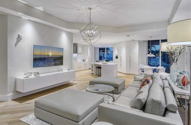 living room with light hardwood / wood-style flooring and a notable chandelier