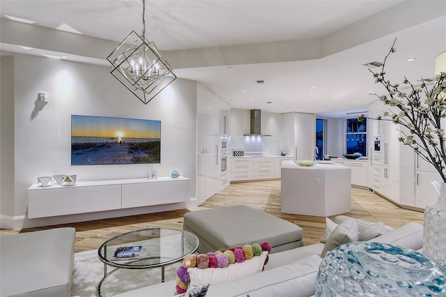 living room featuring sink, an inviting chandelier, and light hardwood / wood-style floors