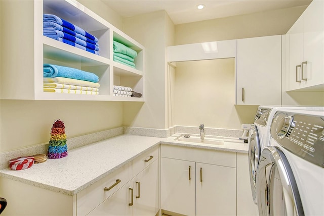 laundry area with cabinets, independent washer and dryer, and sink