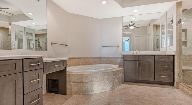 bathroom with tiled bath, double vanity, tile flooring, and ceiling fan