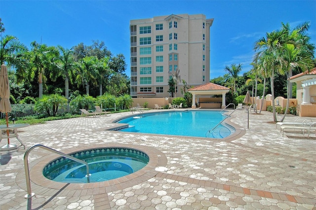 view of swimming pool featuring a community hot tub, a patio area, and a gazebo