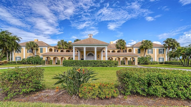 mediterranean / spanish home with a front lawn