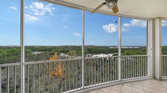 unfurnished sunroom featuring ceiling fan and a wealth of natural light