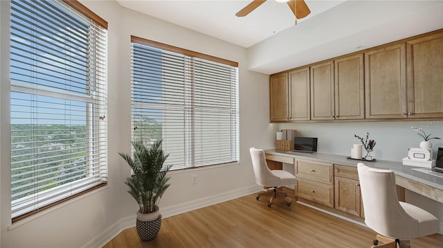 office space featuring light hardwood / wood-style floors, ceiling fan, and built in desk