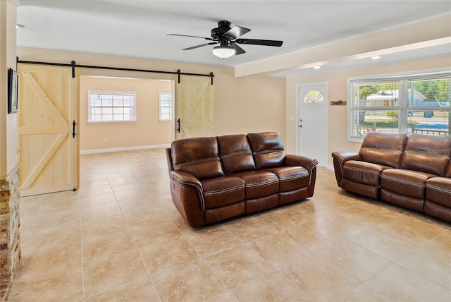 living room featuring ceiling fan and a barn door