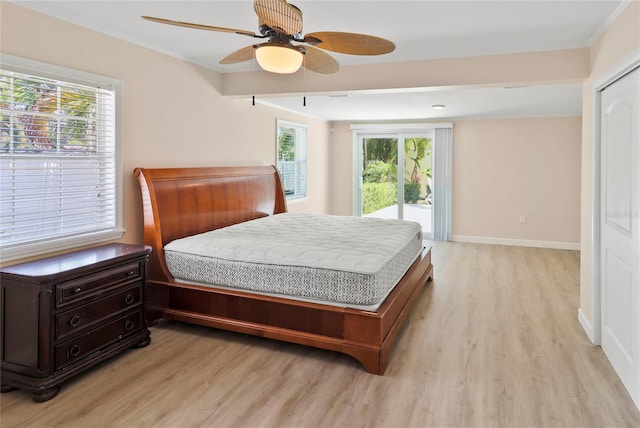 bedroom with ceiling fan, access to exterior, multiple windows, and light hardwood / wood-style flooring