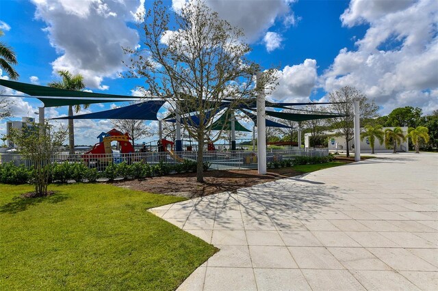 view of community featuring a playground and a lawn