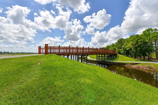 dock area with a water view and a yard