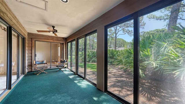 unfurnished sunroom with ceiling fan