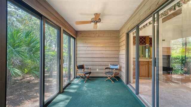 unfurnished sunroom featuring ceiling fan