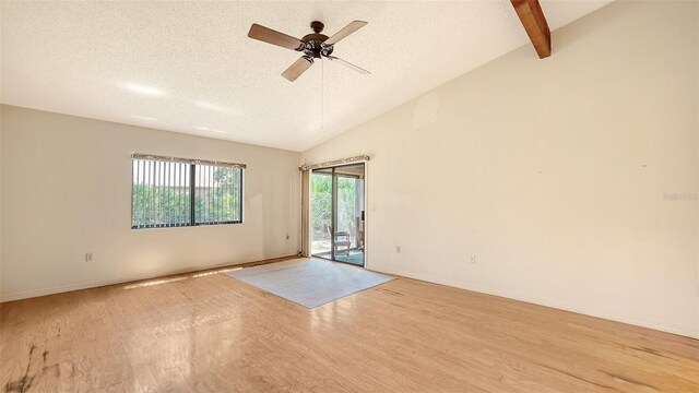 empty room with ceiling fan, light hardwood / wood-style floors, a textured ceiling, and vaulted ceiling with beams