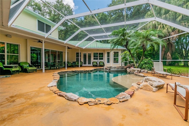 view of swimming pool featuring ceiling fan, a lanai, a patio area, and french doors