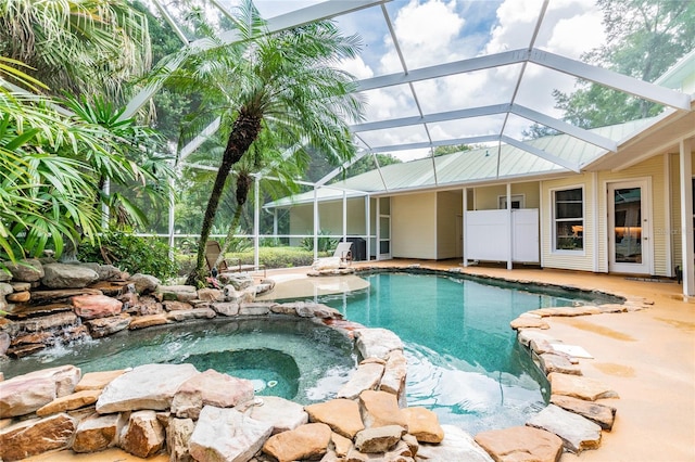 view of swimming pool featuring an in ground hot tub, glass enclosure, and a patio