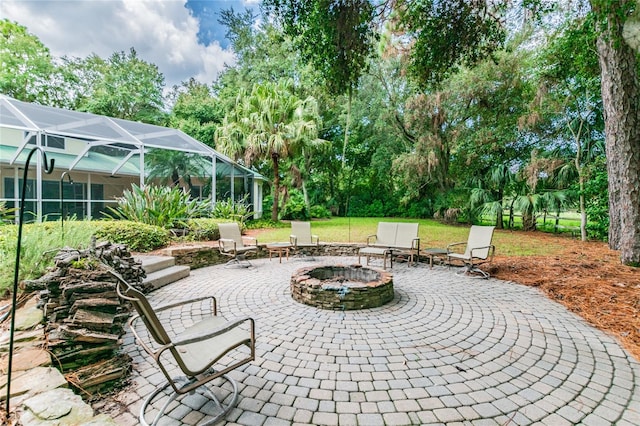 view of patio featuring a fire pit and glass enclosure