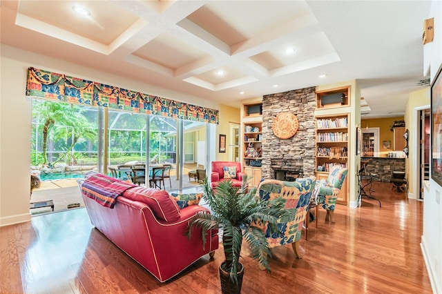 living room featuring beamed ceiling, built in features, coffered ceiling, a fireplace, and hardwood / wood-style flooring