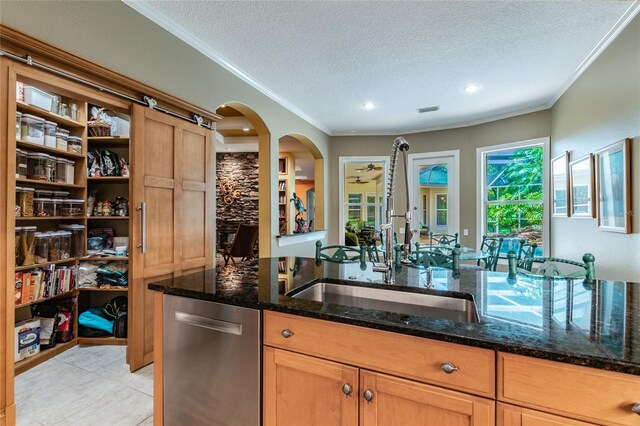 kitchen with dark stone countertops, a textured ceiling, crown molding, and dishwasher