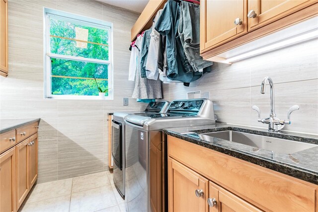 laundry room with sink, tile walls, independent washer and dryer, and plenty of natural light