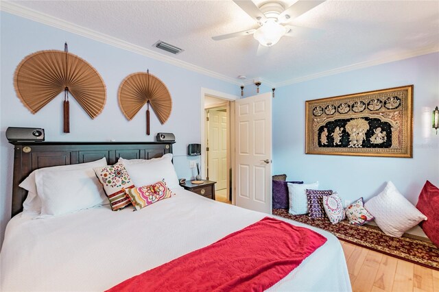 bedroom featuring crown molding, ceiling fan, a textured ceiling, and wood-type flooring