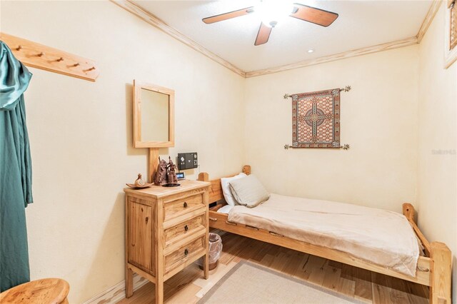 bedroom featuring ceiling fan, crown molding, and dark wood-type flooring