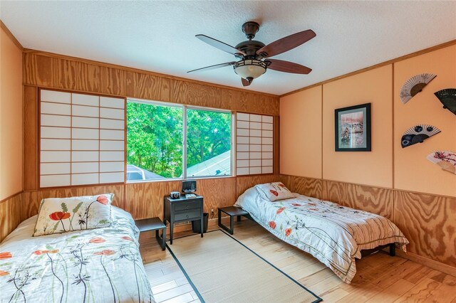 bedroom featuring a textured ceiling, ceiling fan, and light wood-type flooring