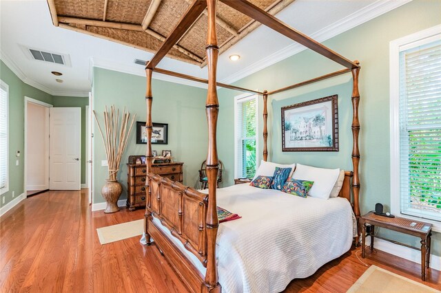 bedroom with crown molding and light wood-type flooring