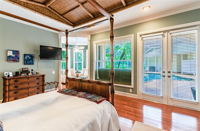 bedroom with access to outside, crown molding, wood-type flooring, and french doors