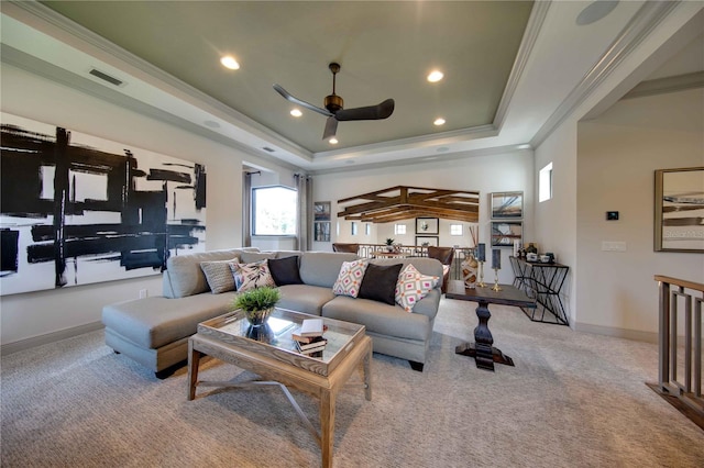 living room with crown molding, ceiling fan, a raised ceiling, and carpet floors