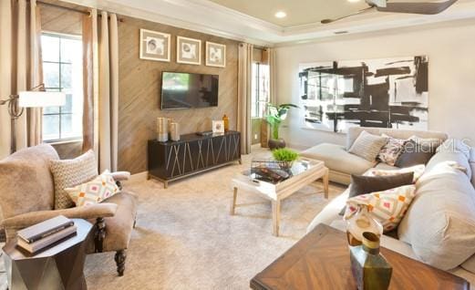 living room featuring crown molding, ceiling fan, a raised ceiling, and carpet