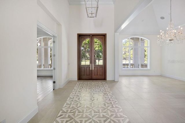 tiled foyer entrance featuring high vaulted ceiling, beamed ceiling, french doors, and an inviting chandelier