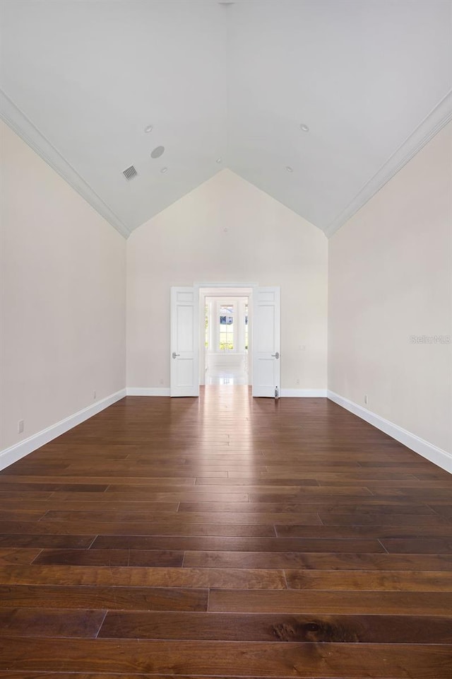 spare room featuring ornamental molding, high vaulted ceiling, and dark wood-type flooring