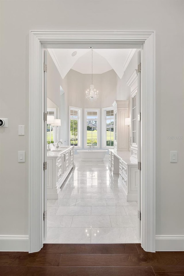 interior space featuring tile floors, an inviting chandelier, and ornamental molding