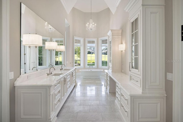 bathroom featuring oversized vanity, a high ceiling, a tub, tile floors, and an inviting chandelier