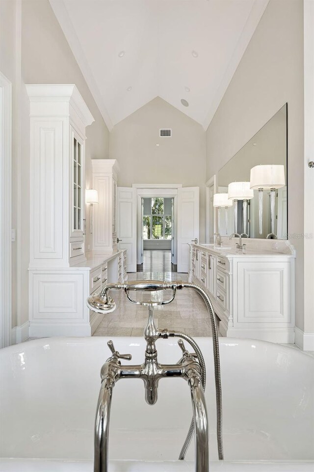 interior space featuring high vaulted ceiling and white cabinetry