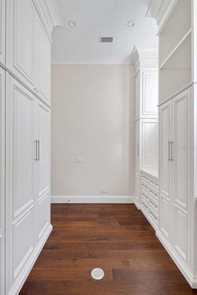 unfurnished bedroom with crown molding and dark hardwood / wood-style floors