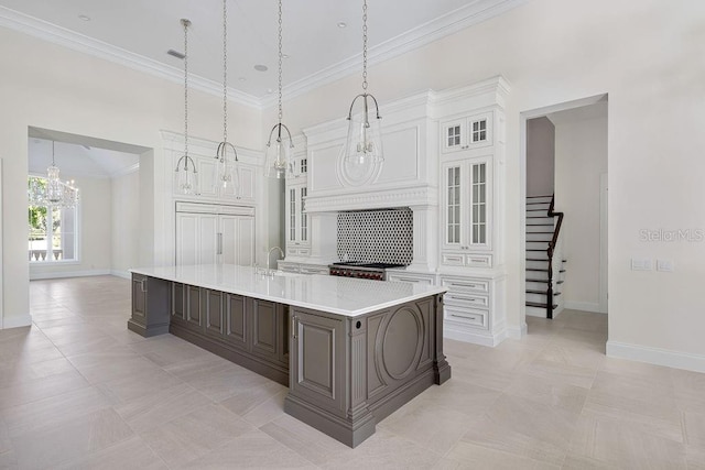 kitchen with white cabinets, backsplash, light tile flooring, hanging light fixtures, and a large island