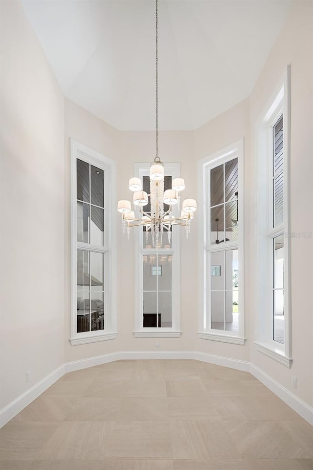 unfurnished room featuring an inviting chandelier