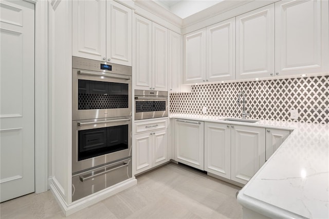 kitchen featuring stainless steel double oven, white cabinets, and sink