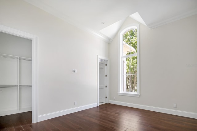 interior space with ornamental molding, a closet, dark hardwood / wood-style floors, and vaulted ceiling