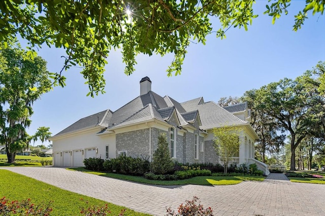 view of side of home featuring a garage and a lawn