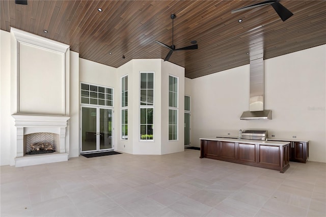 unfurnished living room with a large fireplace, ceiling fan, light tile floors, and wood ceiling