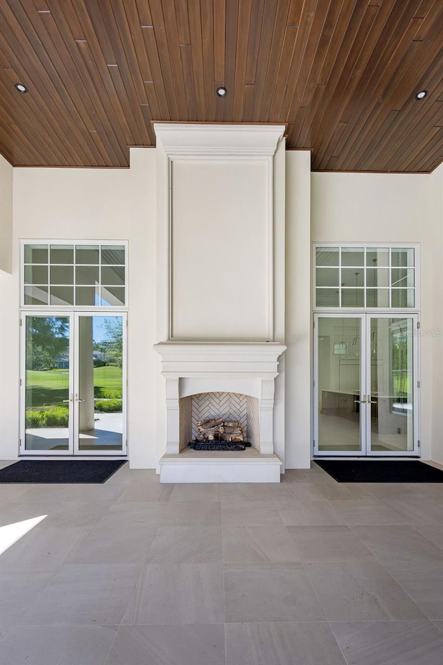 unfurnished living room featuring french doors, wood ceiling, and tile floors