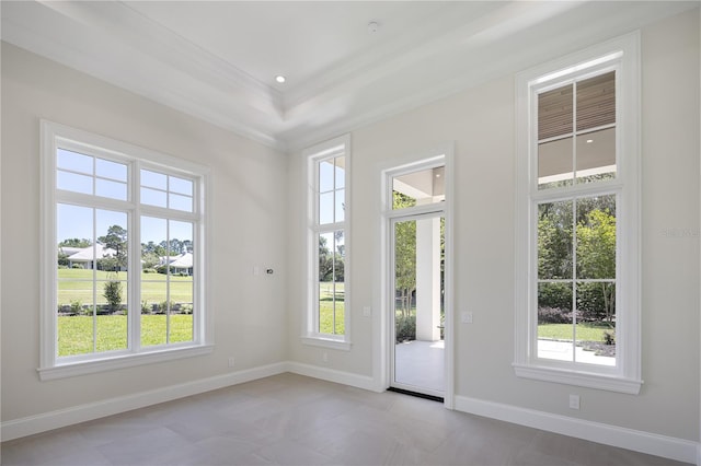 spare room featuring light tile floors and a tray ceiling