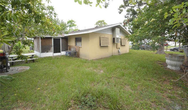 rear view of property with a sunroom and a lawn