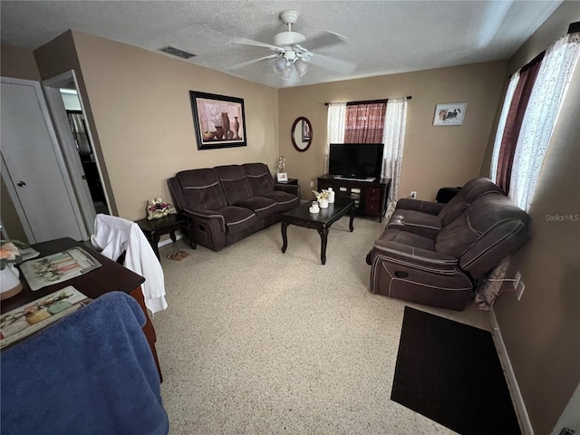 living room with a textured ceiling and ceiling fan